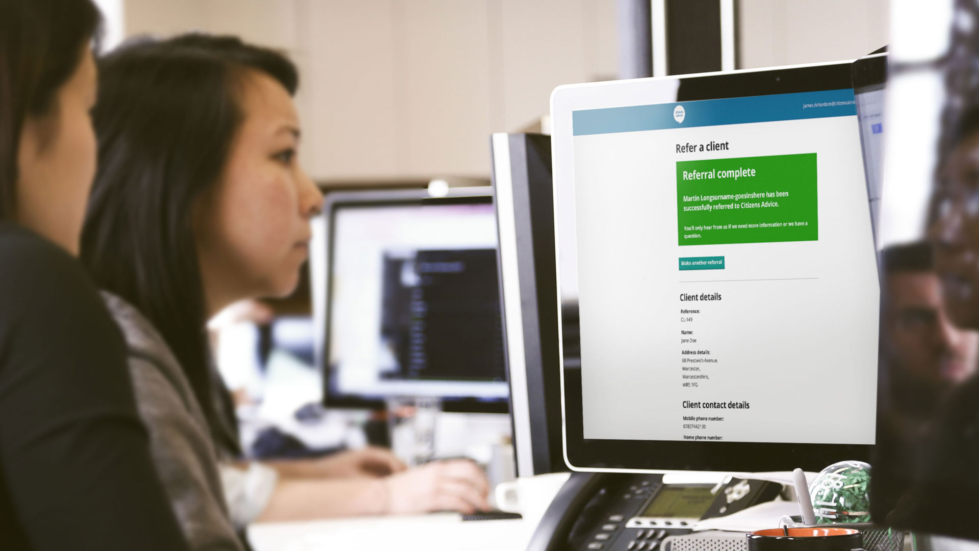 A womon looking at a computer screen showing the completion page of the Referrals product